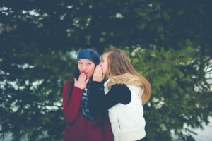 Amiga contándole un secreto a otra