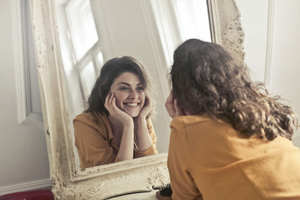 Mujer feliz viéndose en un espejo