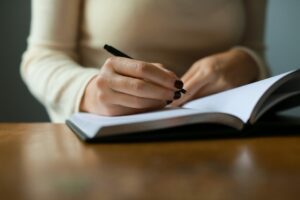 Persona escribiendo en una libreta.