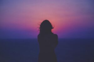 Silueta de una mujer viendo el ocaso